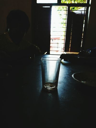 Reflection of man in drinking glass