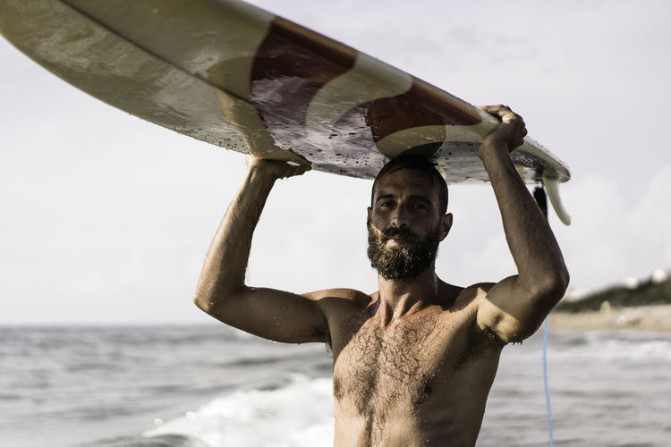 Full length of shirtless man standing on beach
