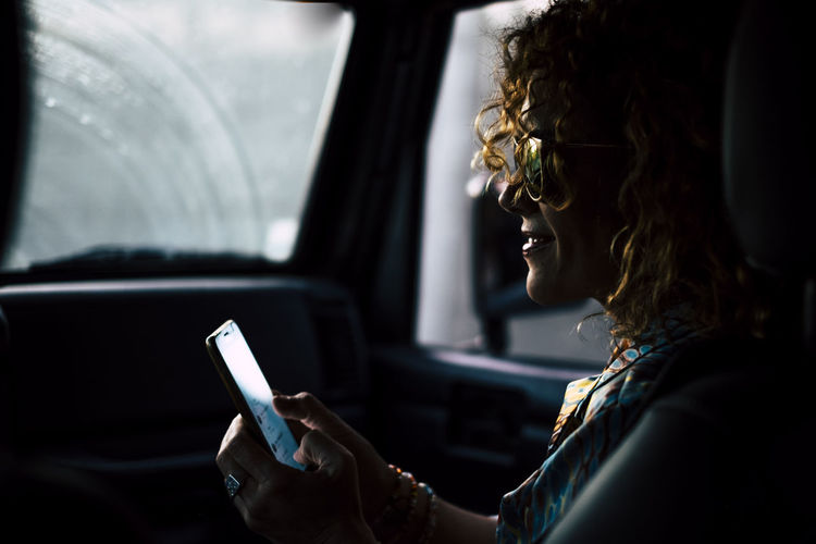 Woman using mobile phone in car