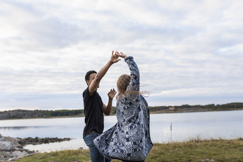 Young couple dancing on lakeshore