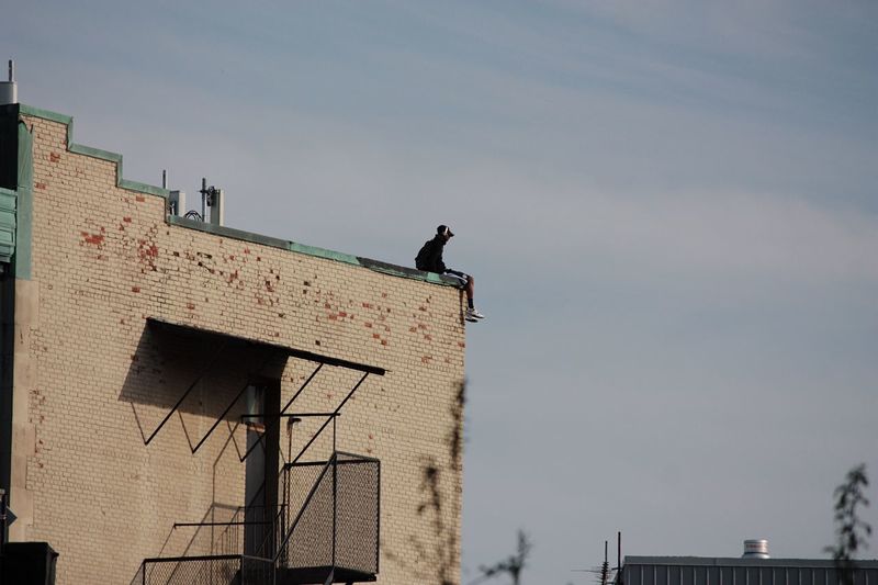 Low angle view of man on building against sky