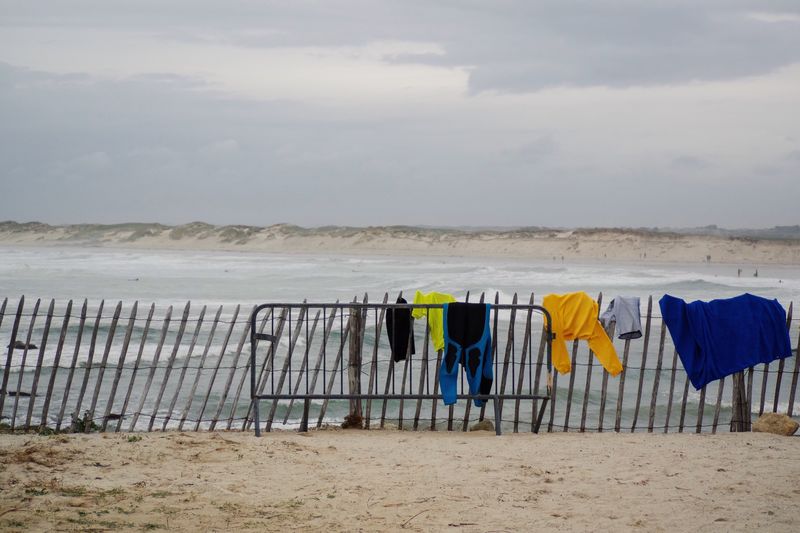 Clothes drying on beach against sky