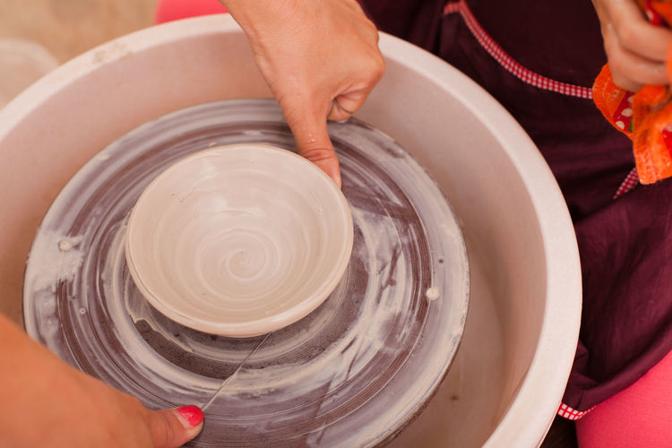Midsection of girl using pottery wheel