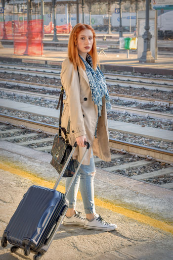 Portrait of woman standing at railroad station platform
