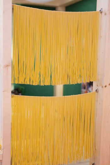 Close-up of yellow drying on table against wall