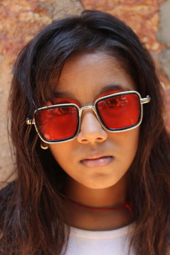 Close-up portrait of a serious young woman with sunglasses