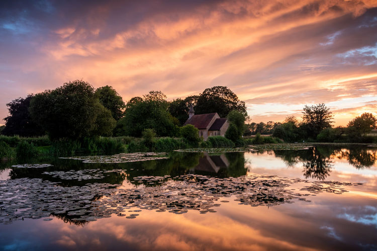 Church reflections on a lake during a bright sunset, st leanards church