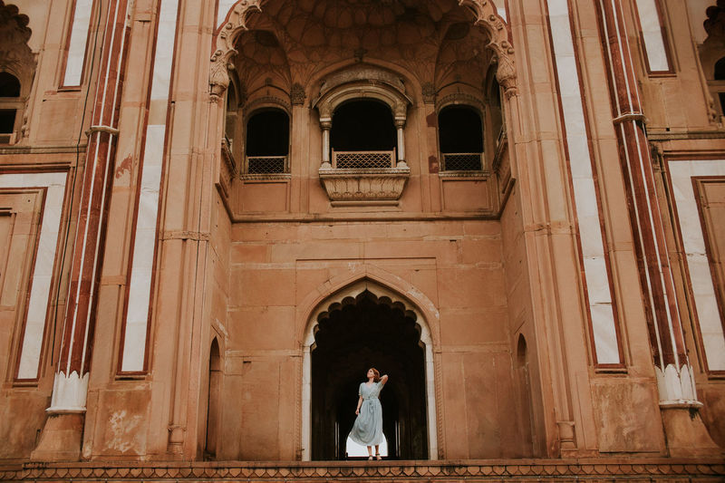 From below full body of female traveler standing against archway of safdarjungs tomb historic landmark of new delhi