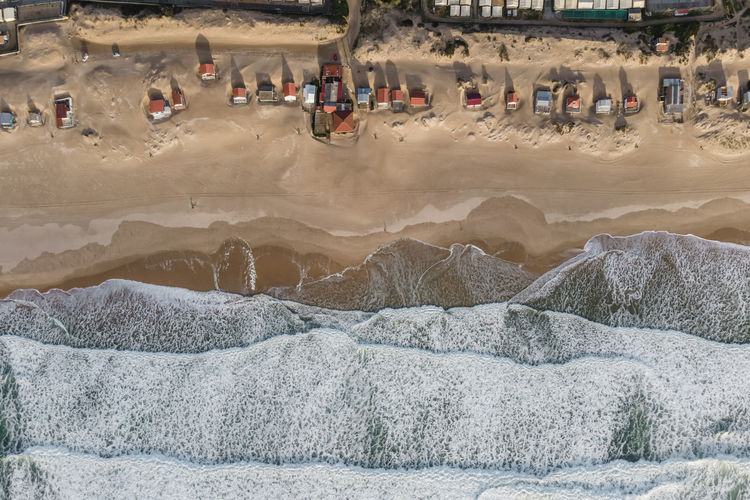Portugal, setubal district, costa da caparica, drone view of suburban houses standing along sandy coastal beach