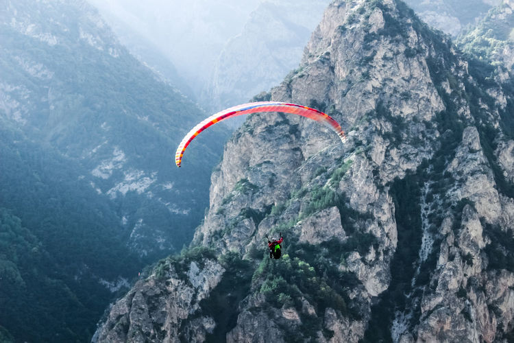 People paragliding on mountain peak