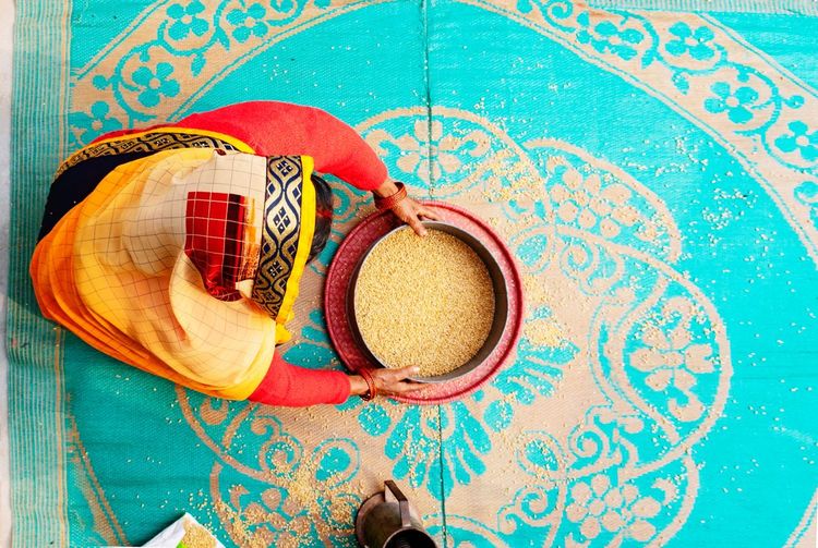 High angle view of woman cleaning wheat at home