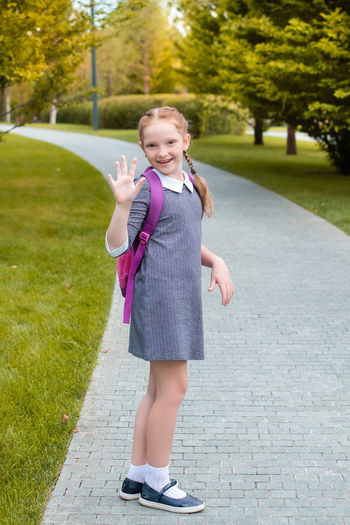 Portrait of a smiling girl standing on footpath