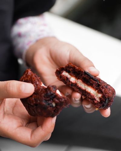 Close-up of hand holding red velvet cookie