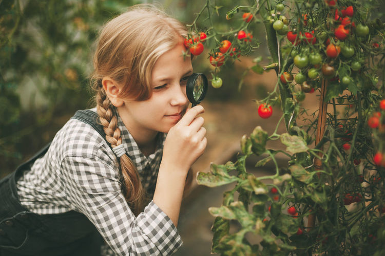 Girl looking away against plants
