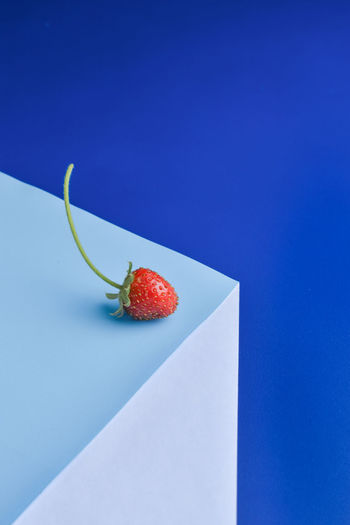 Close-up of strawberry on table against blue background