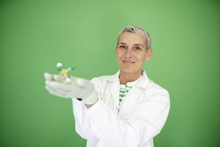 Portrait of female doctor holding dentures