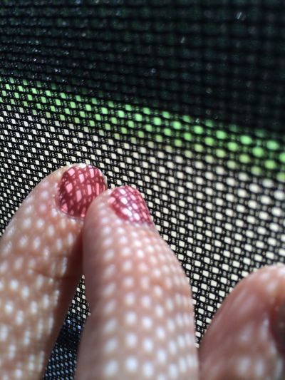 Close-up of woman fingers by net