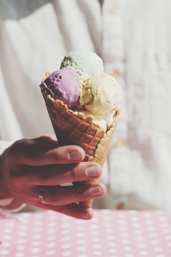 Close-up of woman holding ice cream cone at home