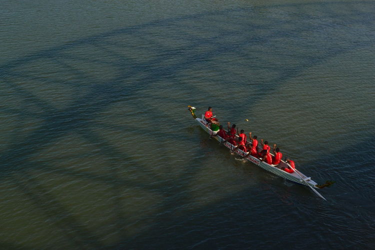 High angle view of people sitting on rowboat in river