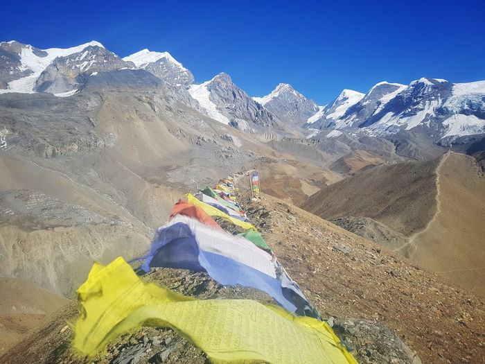 Colorful prayer flags on land against snowcapped mountain
