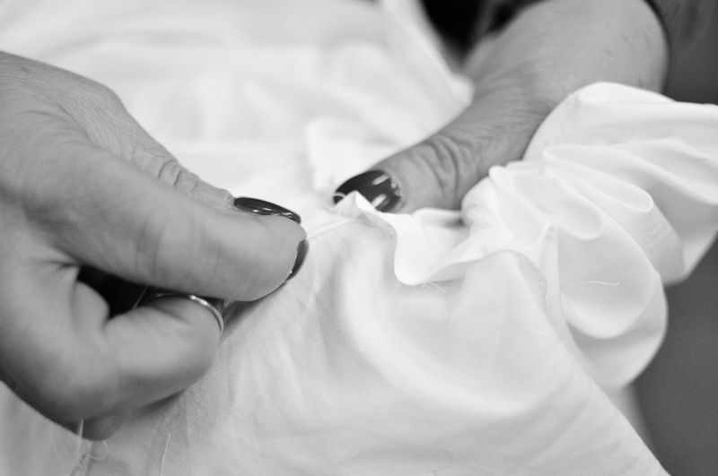 Cropped hands of woman sewing textile