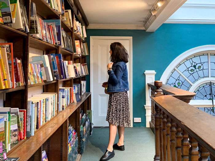 Daunt books shop in marylebone. woman looking for book. bookshelf with books, library. student