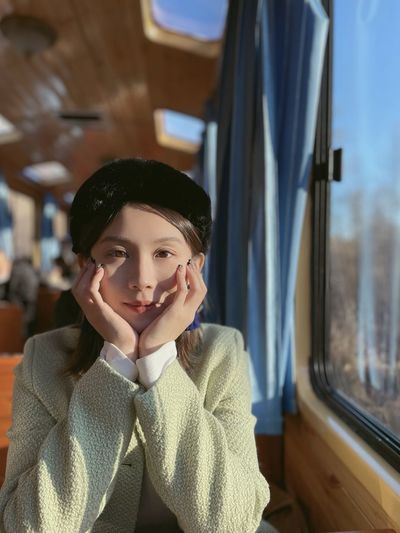 Portrait of young woman sitting in train