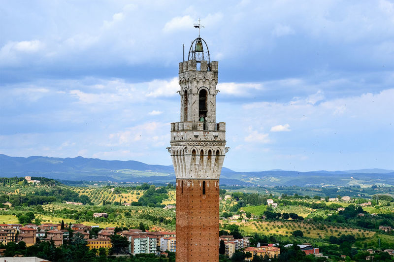 Torre del mangia in city against cloudy sky