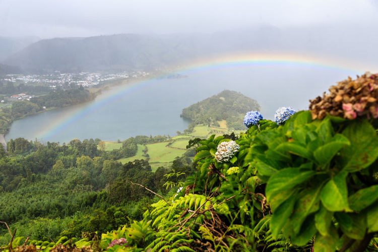 Scenic view of rainbow over land and mountains
