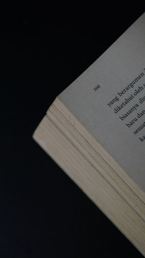 High angle view of book on table against black background