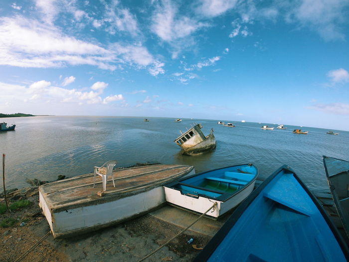 Boats moored on sea against blue sky