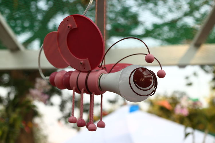 Low angle view of red bell hanging on tree