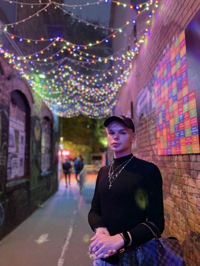 Portrait of man wearing cap standing in alley