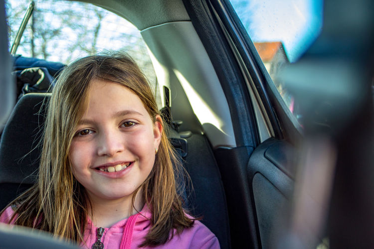 Portrait of smiling girl in car