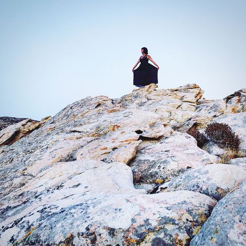 Low angle view of person standing on rock
