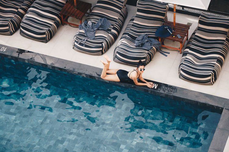 High angle view of woman lying on poolside