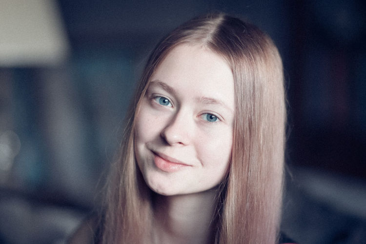 Close-up portrait of smiling teenage girl at home