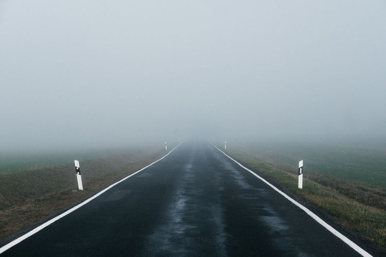 Road amidst foggy weather against sky