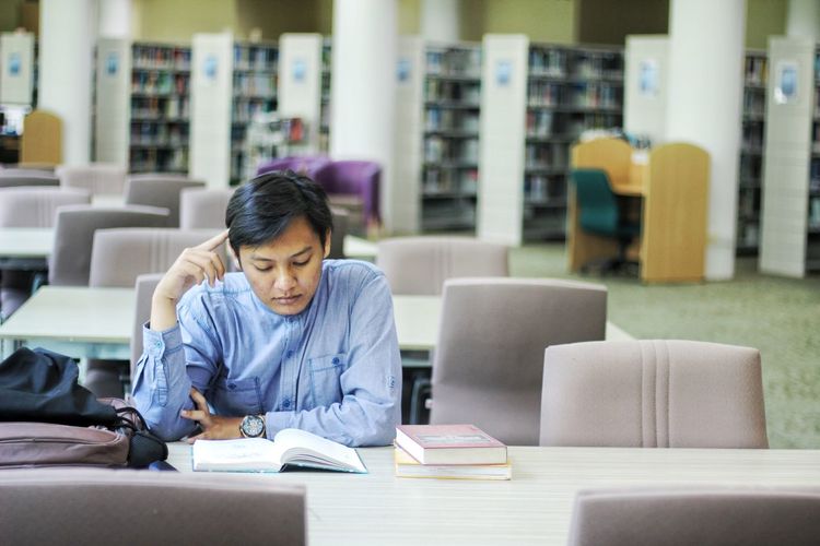 Young student studying in library at university