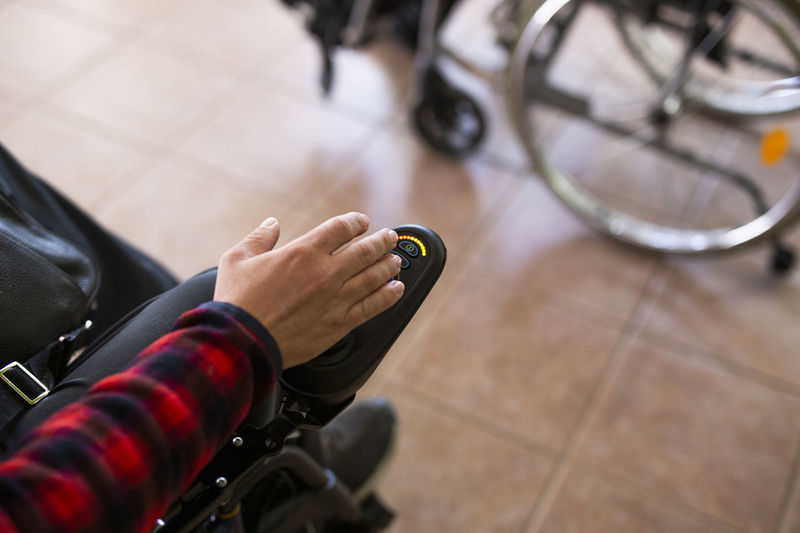 Disabled man's hand on button of motorized wheelchair