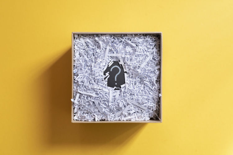 Close-up of mailbox on paper against yellow wall