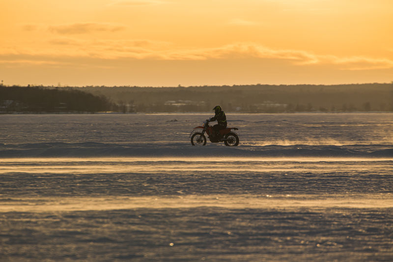 Man riding motorcycle on a  frozen lake