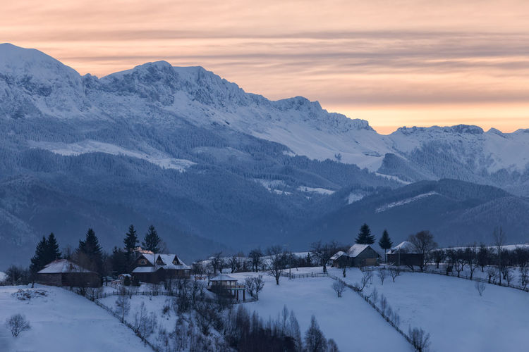 Scenic view of snow mountains against sky during sunset