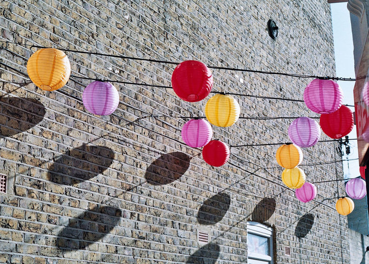Low angle view of multi colored umbrellas hanging on wall