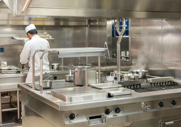 Rear view of chef working in commercial kitchen