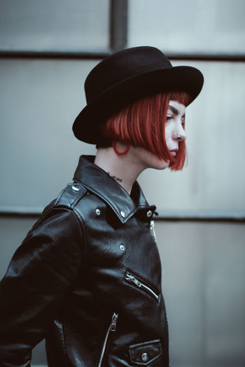 Side view of thoughtful young woman leather jacket at home