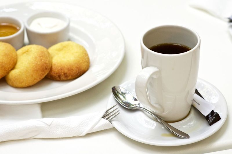 Black coffee with snacks on table