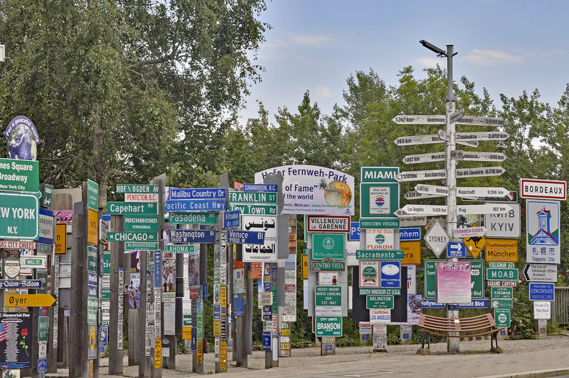 Various signboards on street against trees