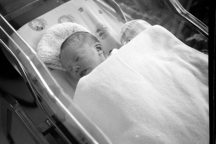 High angle view of newborn baby sleeping in hospital nursery