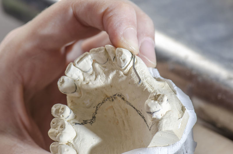 Cropped hands of person working on dentures